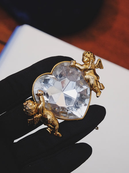 Moschino angels holding a heart brooch