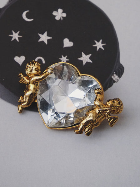 Moschino angels holding a heart brooch