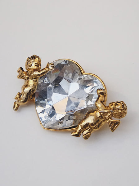 Moschino angels holding a heart brooch